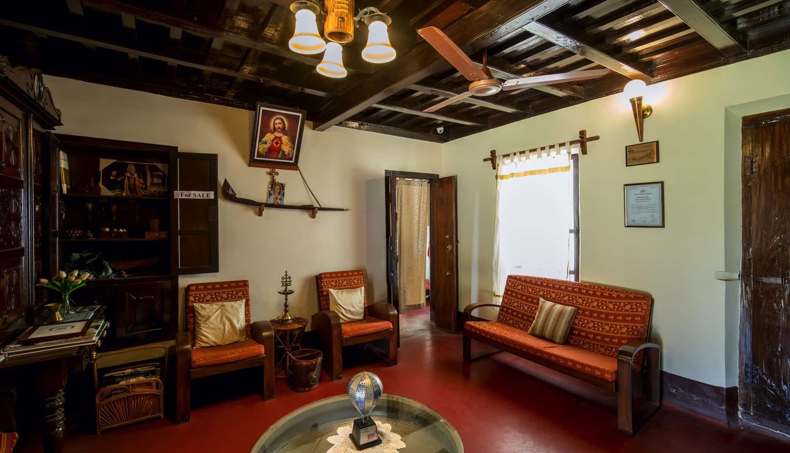 A sitting corner in the house with old furniture, hanging lamps and a beamed ceiling